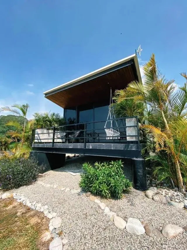 Cabaña moderna con terraza y vegetación tropical en glamping cerca de Bucaramanga.