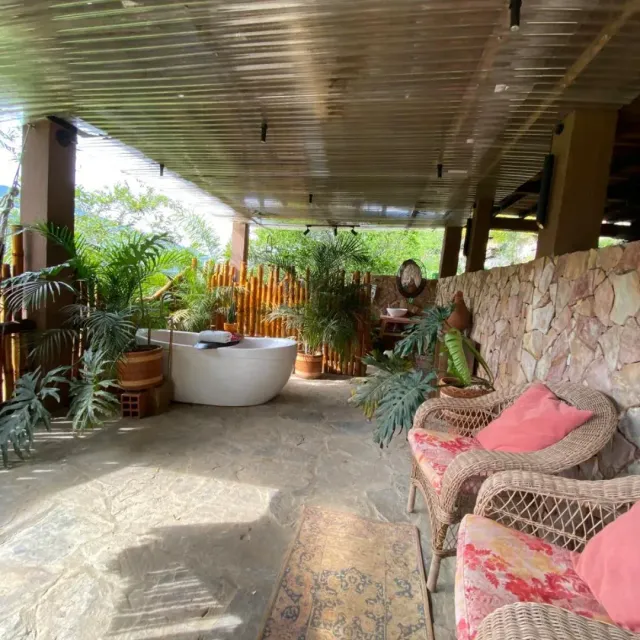 Jacuzzi interior rodeado de plantas y pétalos, espacio de relajación en cabaña de glamping Bucaramanga.