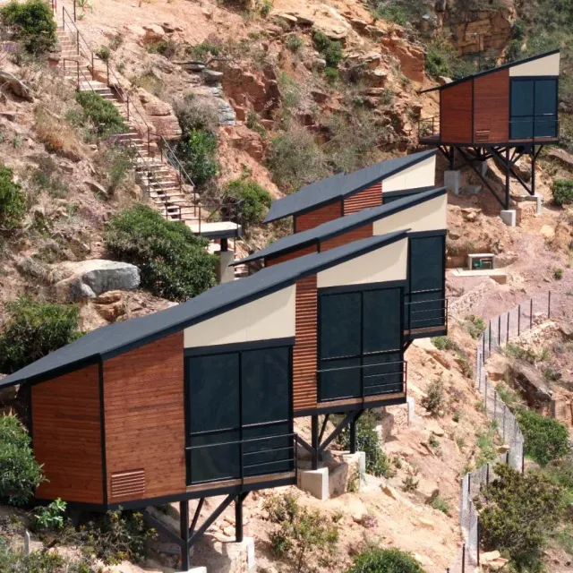Cabañas de lujo elevadas en la montaña, diseño moderno con ventanales y entorno natural, ideales para glamping.