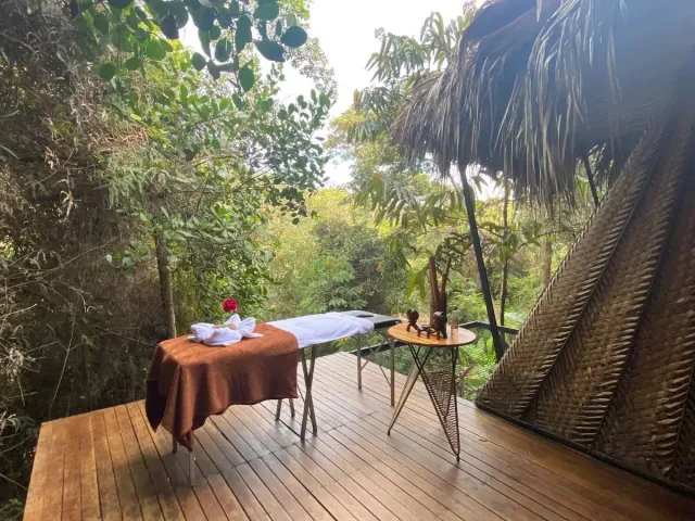 Mesa de masajes al aire libre rodeada de árboles en glamping natural de Bucaramanga. Título (H1):