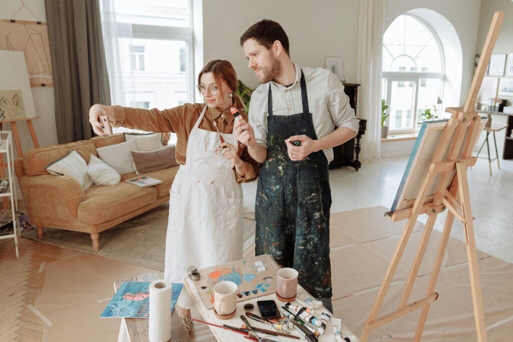 Pareja pintando juntos en un estudio de arte, disfrutando de una actividad creativa