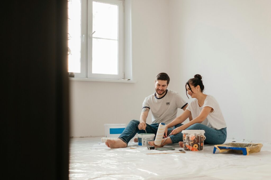 Pareja renovando una habitación juntos, pintando y decorando.